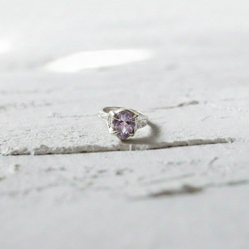 studio shot of the handcrafted Rocky Drop Signet Ring in sterling silver 925, featuring a radiant purple gemstone set in an organic, sculptural frame.